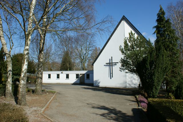 Die Trauerkapelle auf dem Friedhof Hennen zwischen Birken, davor ein Vorplatz